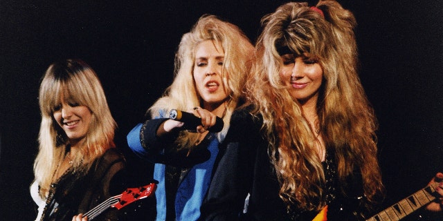 The band Vixen huddled together and performing in 1991