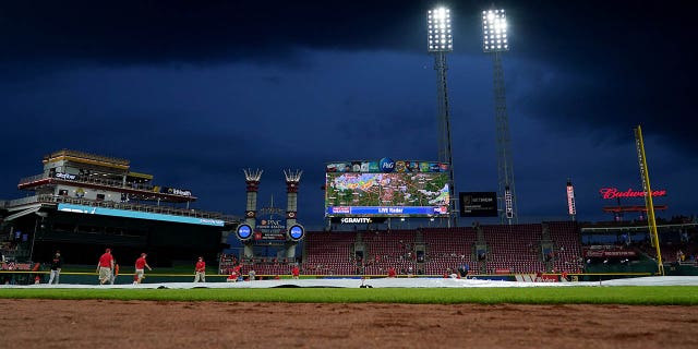 The grounds crew pulls the tarp onto the field.