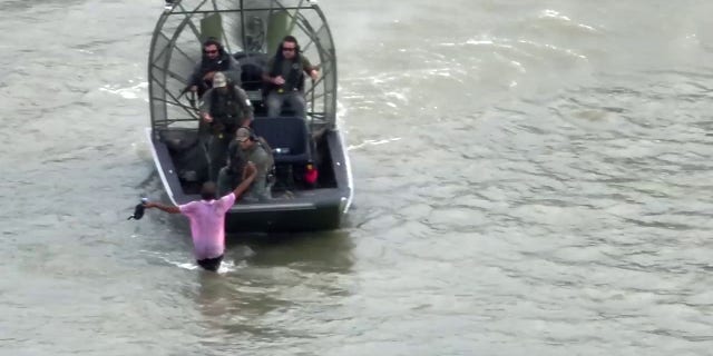 suspect being taken into custody in river