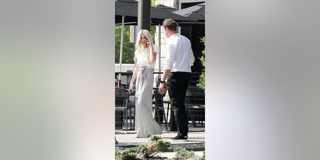 Kim Zolciak and Kroy Biermann walk outside of a church.