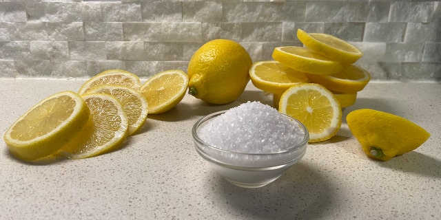 Sliced lemons and glass bowl filled with sea salt.