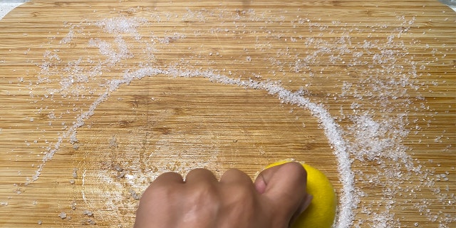 Sliced lemon rubbed onto cutting board.