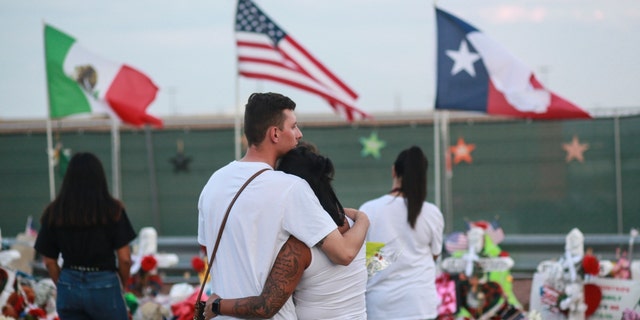 People gather at a makeshift memorial outside the El Paso, Texas, Walmart