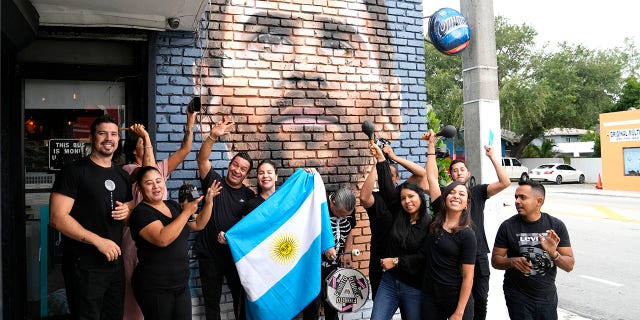 El personal posa frente al mural de Messi