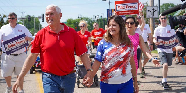 Former Vice President and 2024 Presidential Candidate Mike Pence walks alongside Karen Pence in the Urbandale 4th of July Celebration