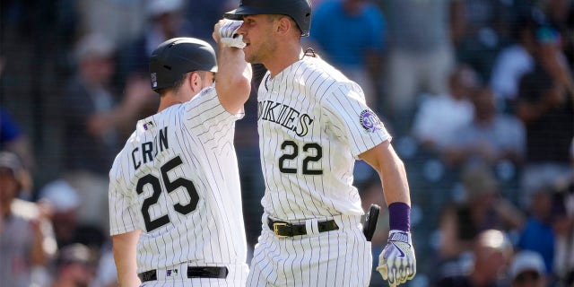 Nolan Jones celebrates with CJ Cron