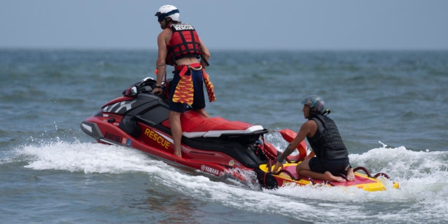 New York lifeguards ride a jet ski during a shark patrol run