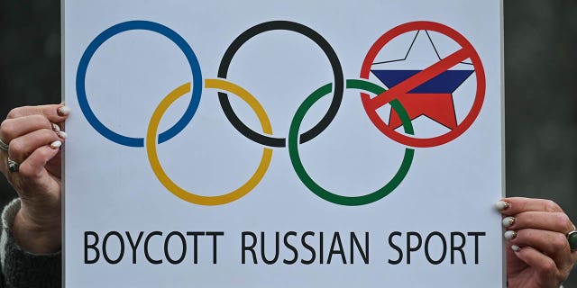 Protester holds a 'Boycott Russian Sport' sign