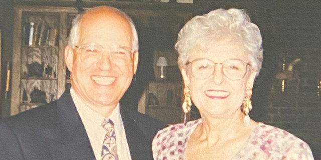 Taw Benderly in a suit and tie next to Loretta Bowersock in a colorful dress as they both smile