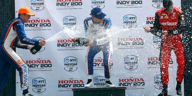 Alex Paulo, Scott Dixon, and Will Power splash champagne