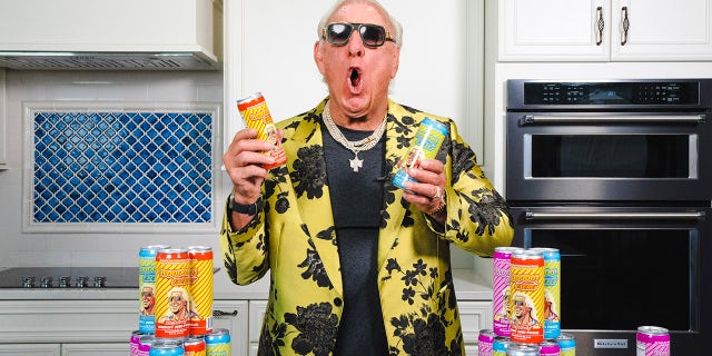 Ric Flair poses with energy drinks