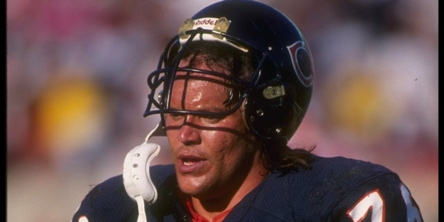 Steve McMichael walks with helmet on head