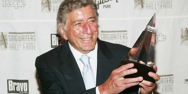 Singer Tony Bennett holding an award