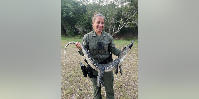 Deputy smiling while holding gator