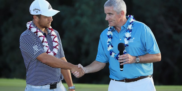 Xander Schauffele shakes hand with PGA Tour Commissioner
