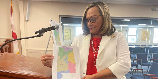 senator holds a copy of a GOP congressional map proposal 