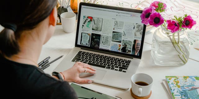 Photo of a woman on her Apple laptop.