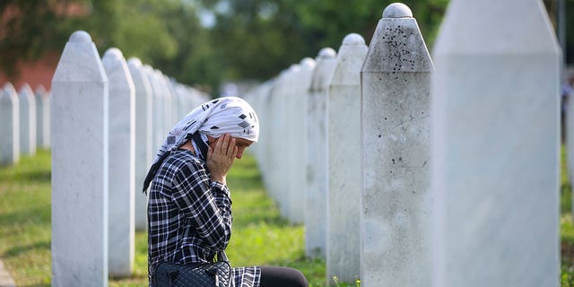Bosnische Frau trauert am Grab