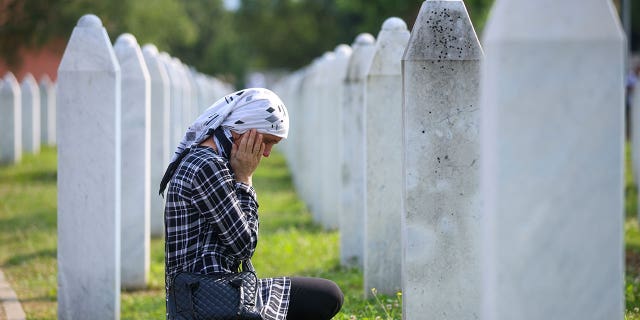 Bosnian woman mourning at grave