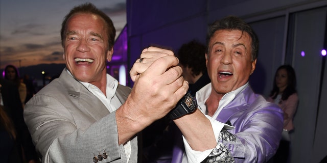 Arnold Schwarzenegger and Sylvester Stallone hold hands and dance in Cannes