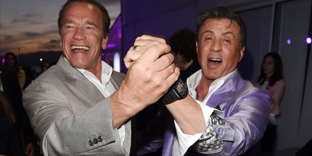 Arnold Schwarzenegger and Sylvester Stallone hold hands and dance in Cannes