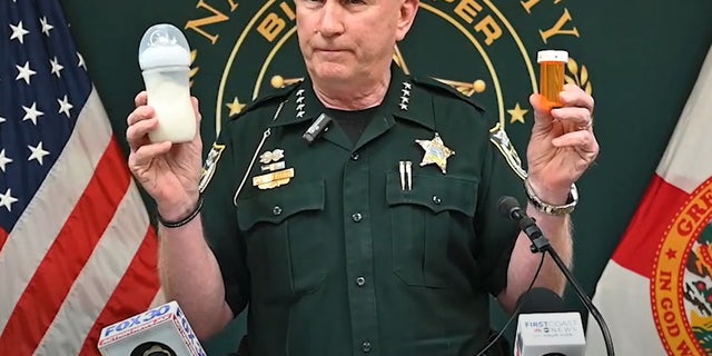 Nassau County Sheriff Bill Leeper holding rx bottle left hand, baby bottle right