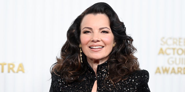 Fran Drescher smiles on red carpet while wearing glittering black dress