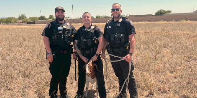 Three officers standing with wrangled goat