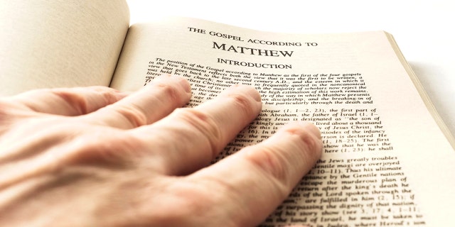 hand resting on the first chapter of the Gospel of Matthew