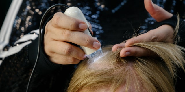 Specialist examines scalp.