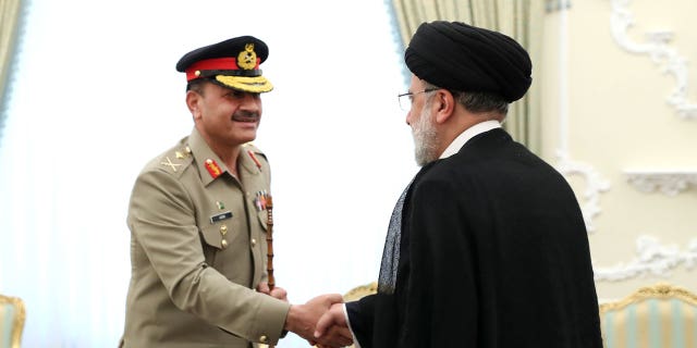 Pakistán e Irán trabajarán juntos para detener los ataques de militantes en la frontera 4 Ibrahim Raisi y Asim Munir se dan la mano