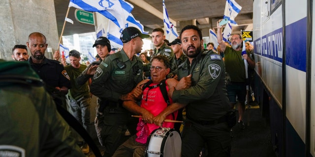 Protestor being escorted from Ben Gurion Airport in Israel