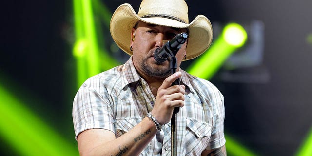 jason aldean singing into a microphone 