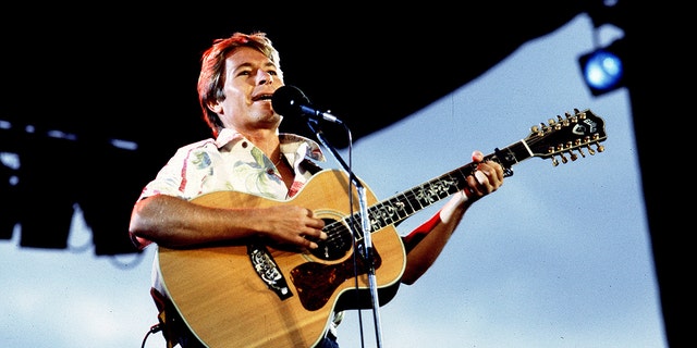 John Denver performing on stage