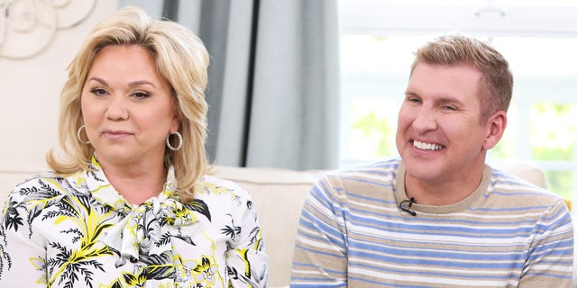 Julie and Todd Chrisley sit on a couch