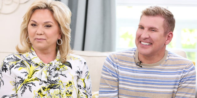 Julie and Todd Chrisley sit on a couch