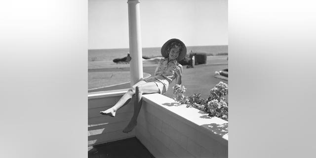 Jackie Kennedy leans back on a balcony in Hyannis Port