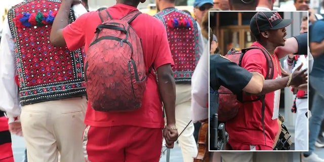 man in red clutching knife in Times Square