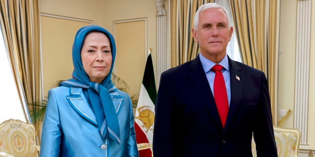 Maryam Rajavi and Mike Pence stand next to each other
