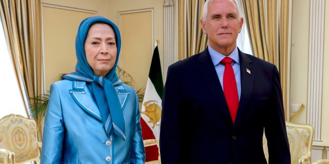 Maryam Rajavi and Mike Pence stand next to each other