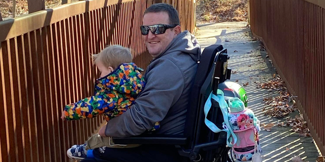 Monte Bernardo in wheelchair holding child