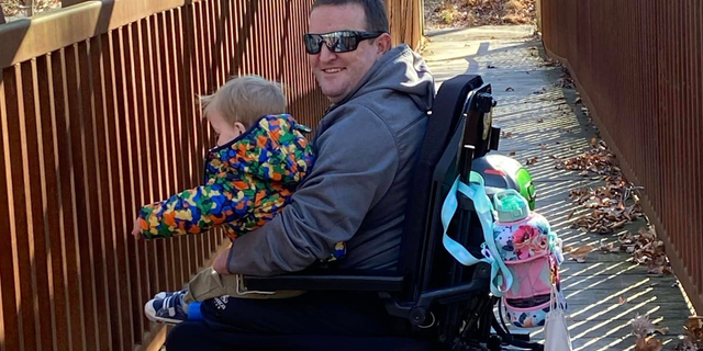 Monte Bernardo in wheelchair holding child