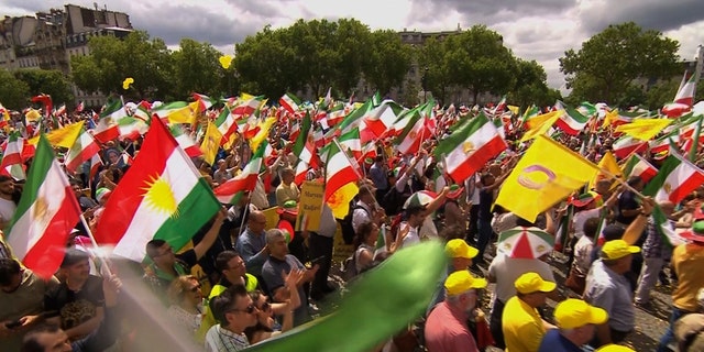 Thousands of people wave Iranian flags in the streets of Paris
