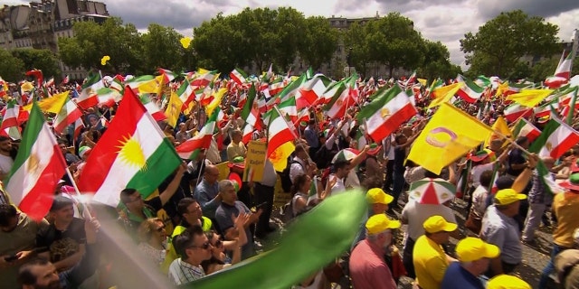 Thousands of people wave Iranian flags in the streets of Paris