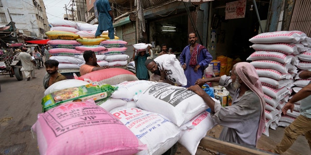 Obreros cargan sacos de lentejas en Pakistán