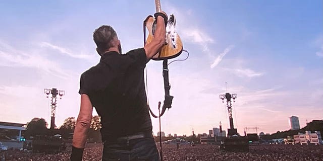 Bruce Springsteen holds up guitar during performance