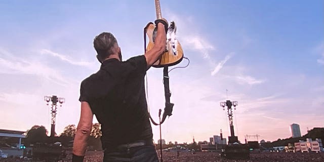 Bruce Springsteen holds up guitar during performance