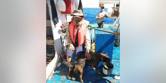 Tim Shaddock sits with his dog Bella