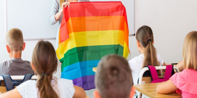 A teacher holding an LGBT flag