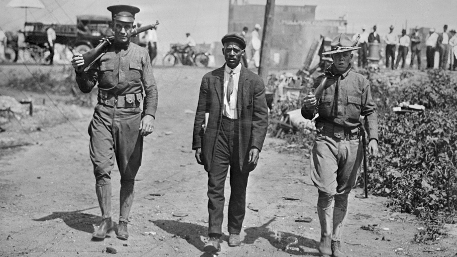 Two guards escort black man